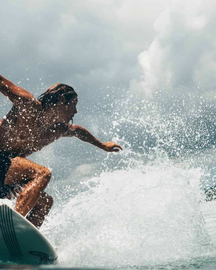 En modig surfer rider bølgerne i det vilde hav med dygtighed og balance, captureret i et øjebliks intens bevægelse og skønhed.