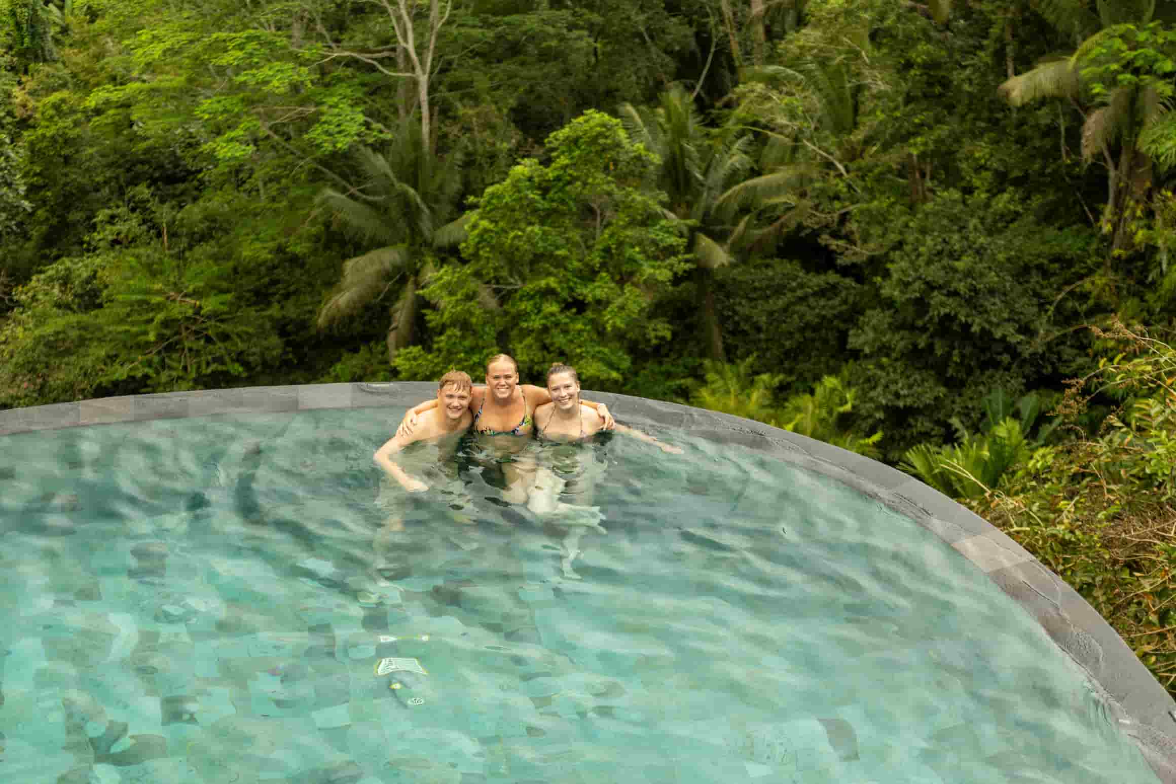 Unge i en infinity pool med udsigt over junglen på Bali