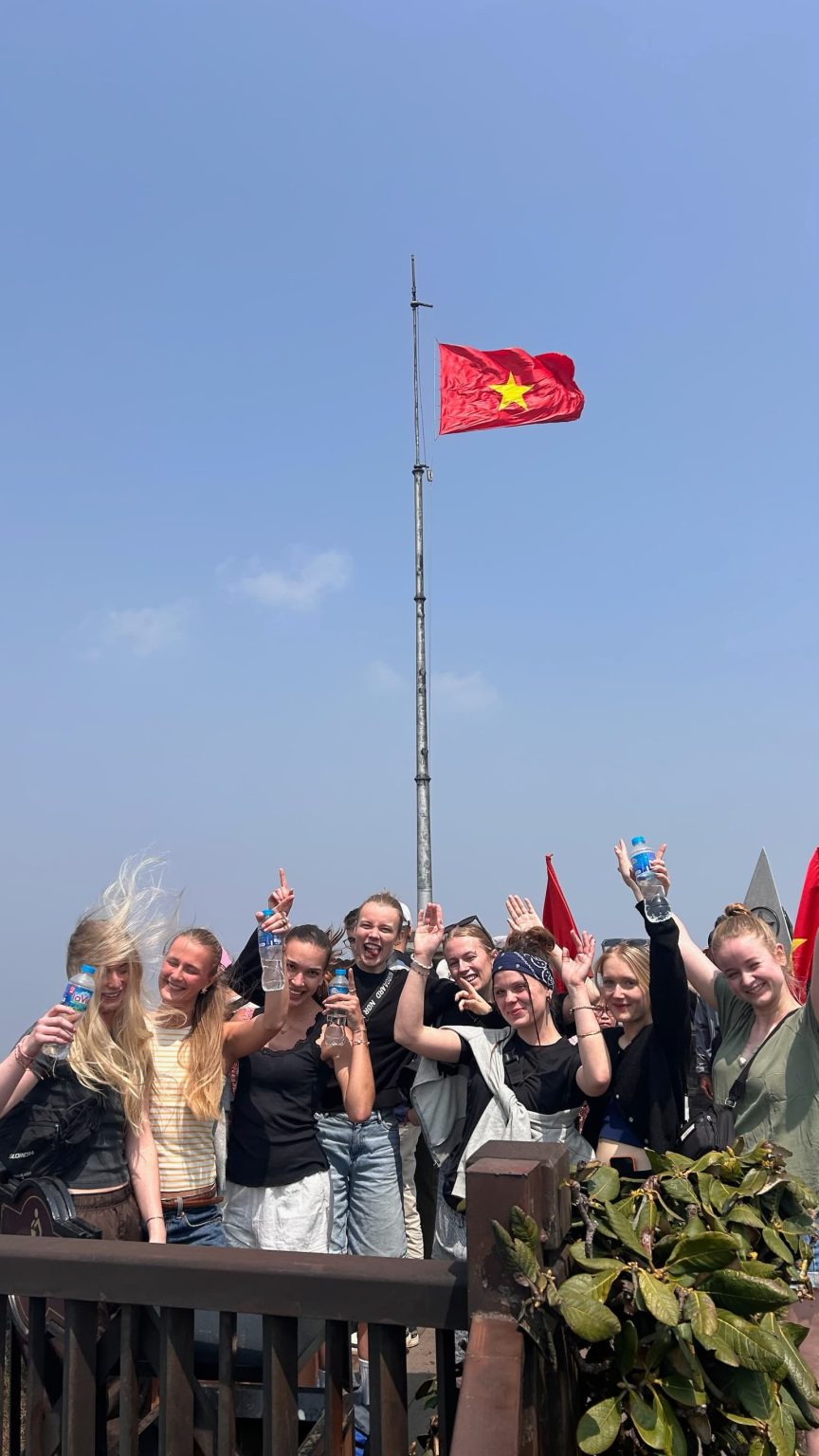 Gruppen med flag på toppen af Fansipan