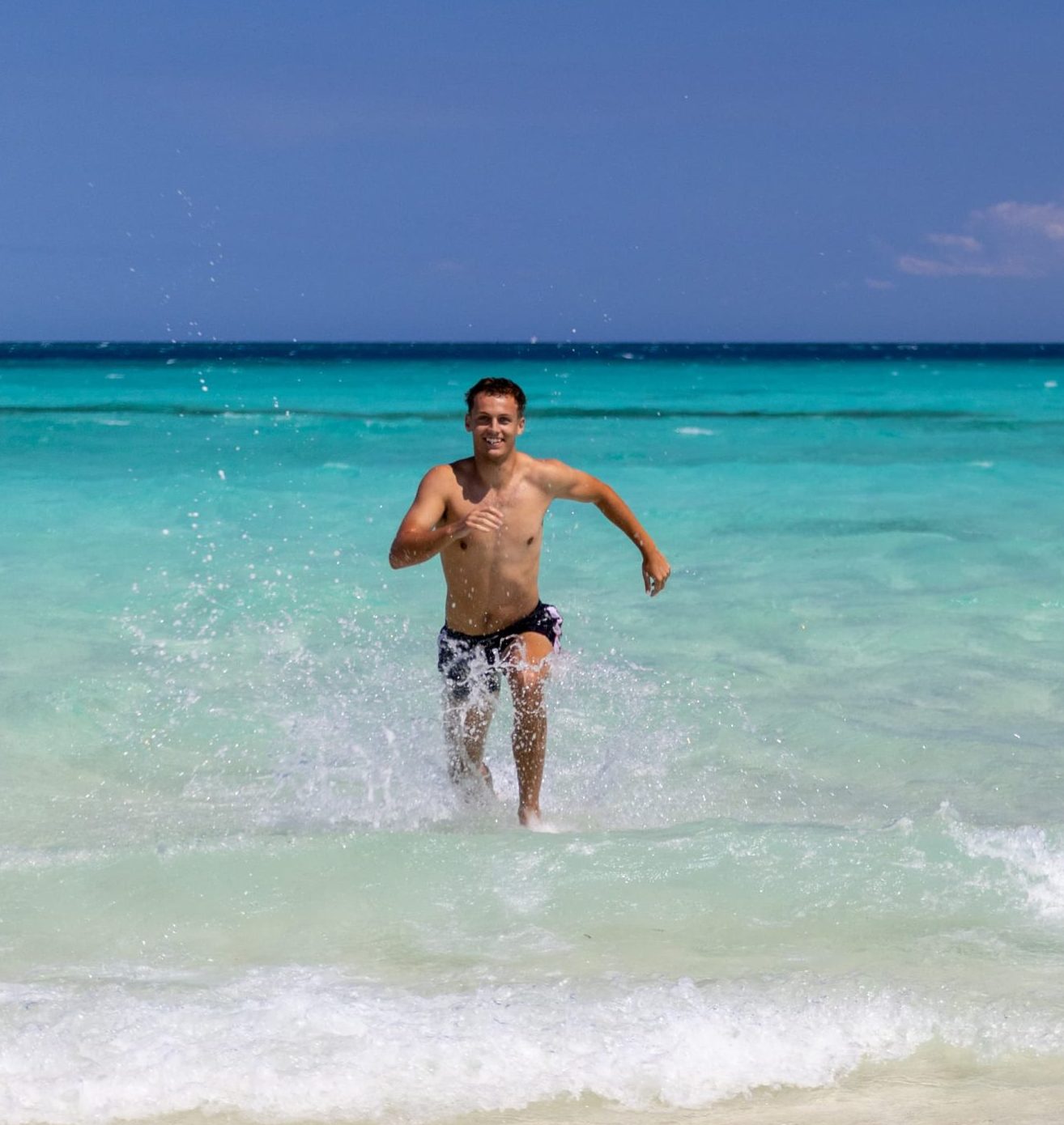 Rejsende løber op af det turkisblå vand på Zanzibar