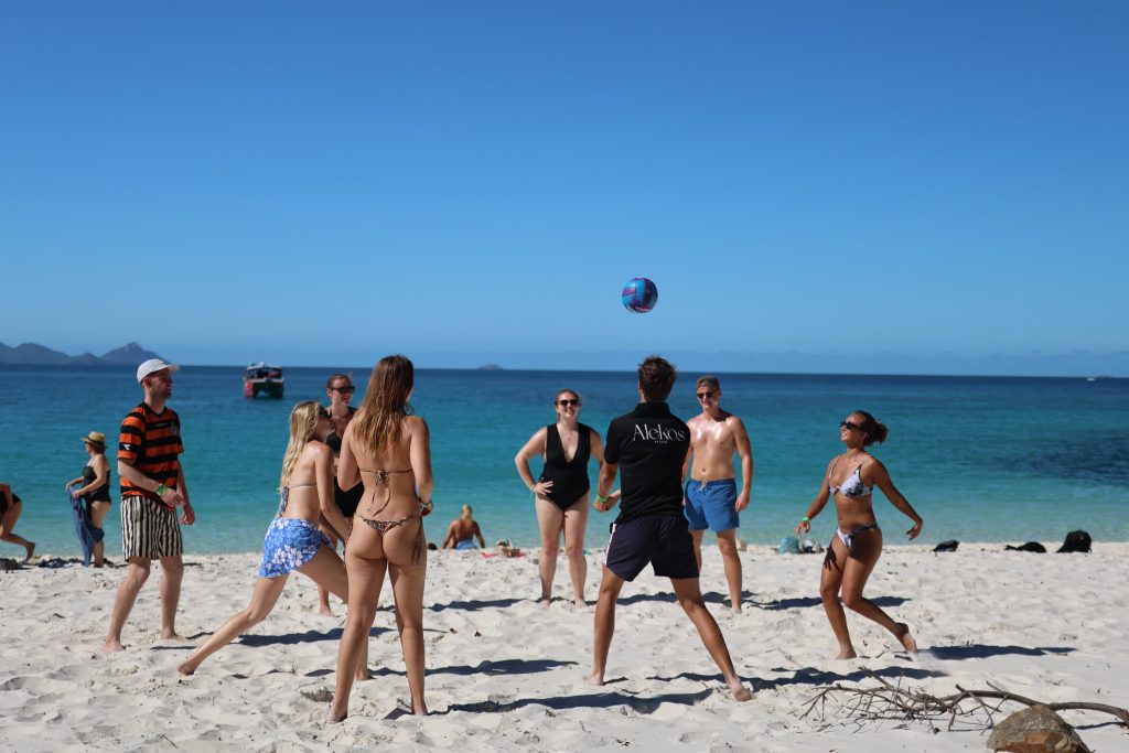 Rejsende spiller beachvolley på stranden