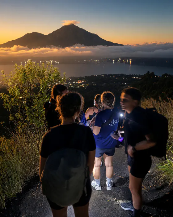Unge med pandelamper på vej op ad Mount Batur i mørket