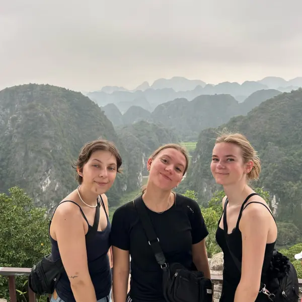 Tre rejsende på toppen af Mua Cave med Ninh Binh i baggrunden