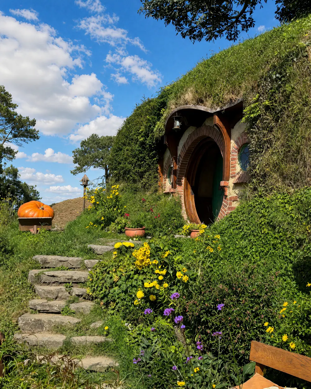 En hobbithule i Hobbiton med blomster foran
