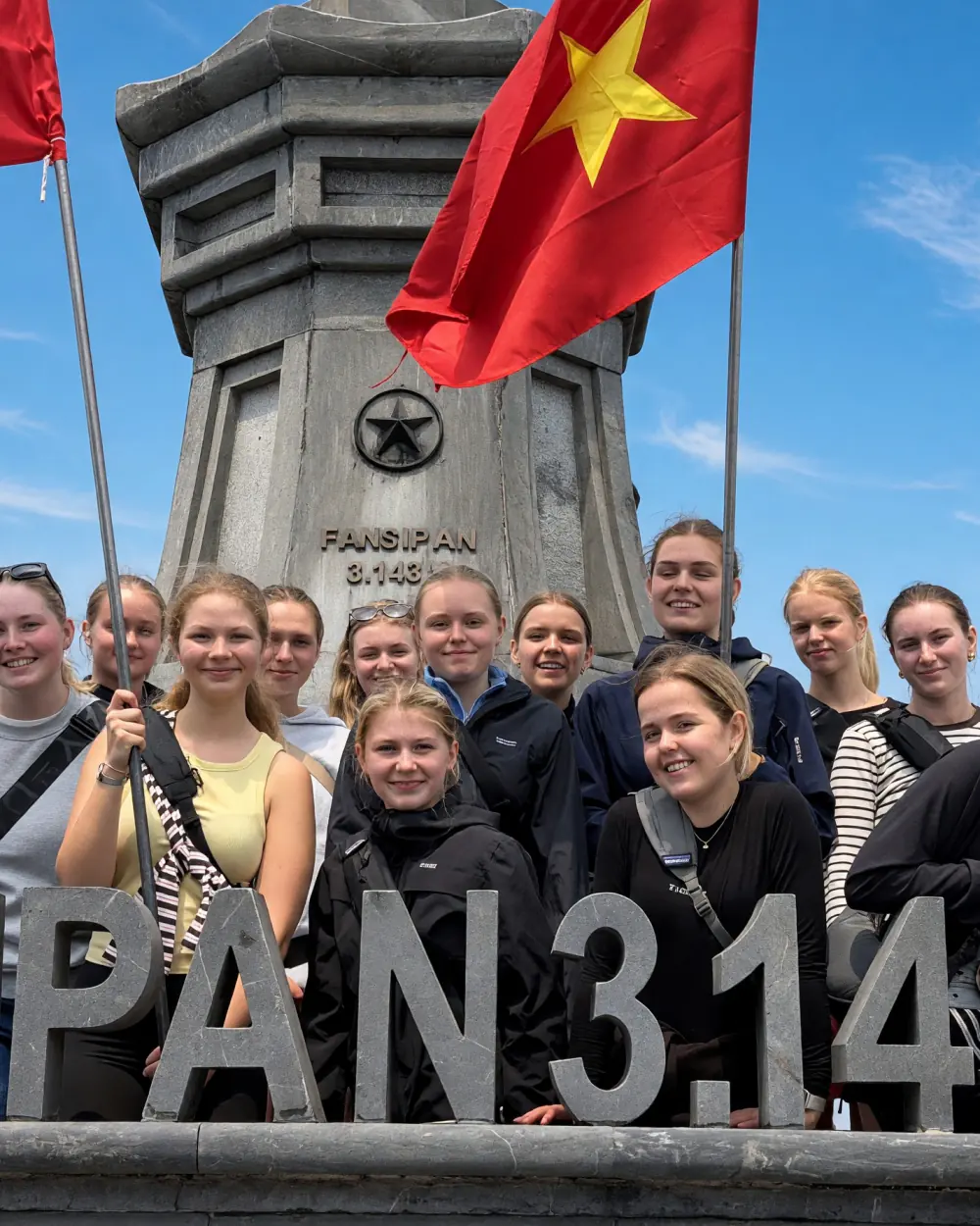 Gruppen samlet ved toppen af Fansipan med det vietnamesiske flag