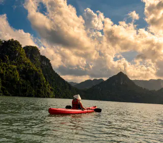 Rejsende i kajak i Ha Long Bay under en dramatisk himmel