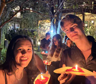 Rejsende med tændte lysbåde under Yi Peng i Chiang Mai